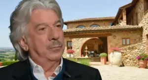 Persona davanti a una tipica casa in pietra in Toscana, con cortile fiorito