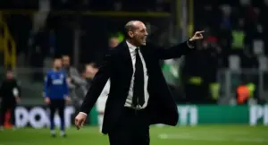 Un allenatore indica con decisione durante una partita di calcio