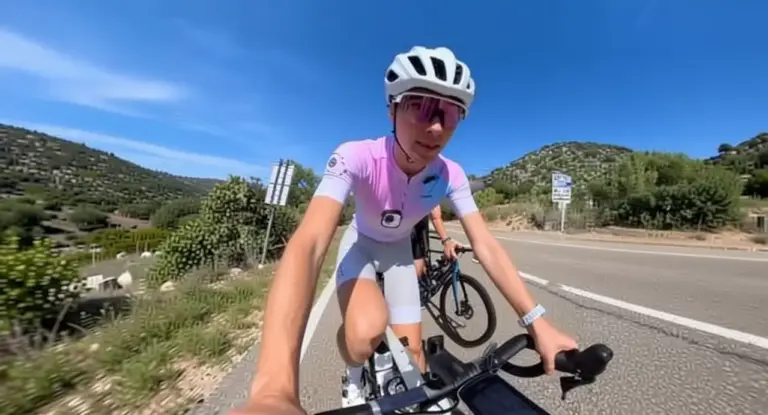 Una persona in bicicletta su una strada panoramica in Sardegna sotto un cielo sereno