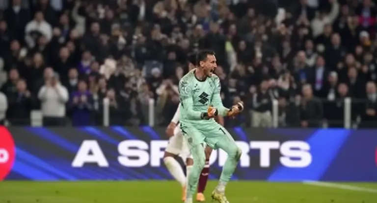 Un portiere esulta in campo durante una partita davanti al pubblico dello stadio