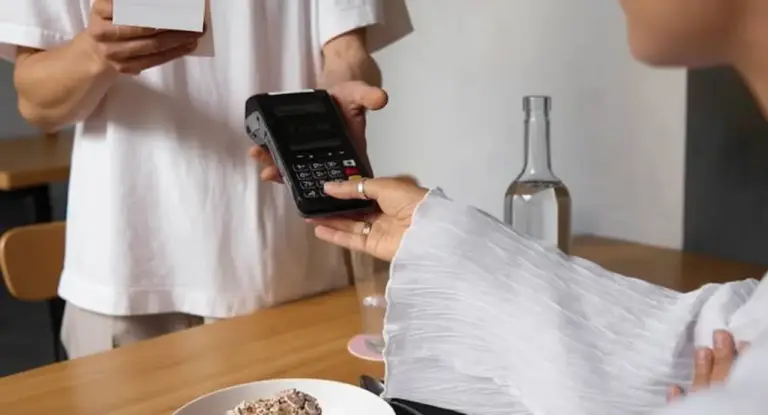 Una persona effettua un pagamento con carta tramite POS in un ristorante