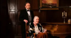 Due persone in un elegante ambiente con pianoforte e arredamento classico